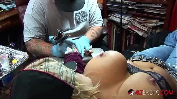 Nouvelles Une pornstar blonde aux gros seins sort ses énormes seins tout en se faisant tatouer le poignet meilleures vidéos